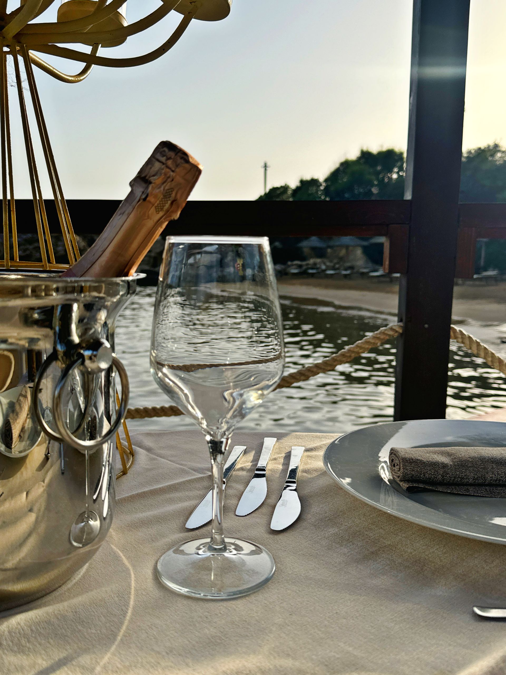 Un tavolo con un bicchiere di vino e una bottiglia di champagne