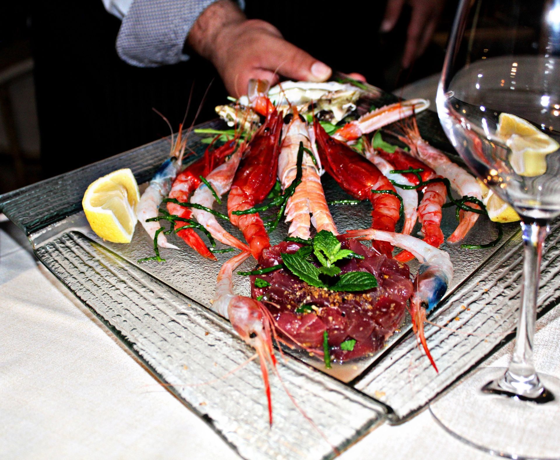 Un piatto di gamberi e un bicchiere di vino su un tavolo
