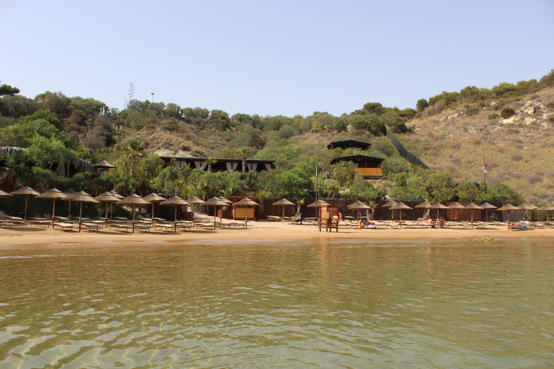 Una spiaggia con molti ombrelloni e sedie