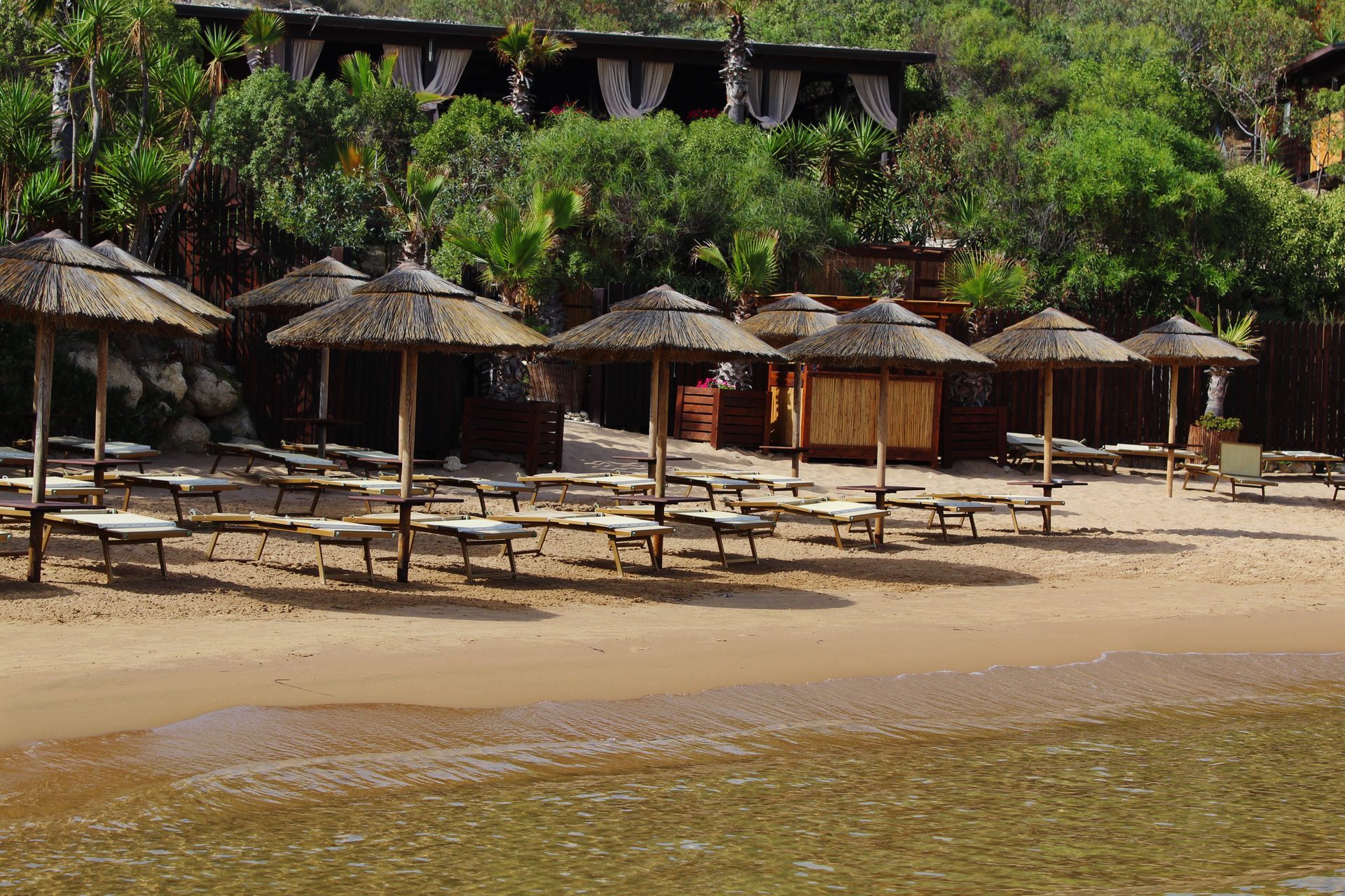 Una spiaggia con molti ombrelloni e sedie