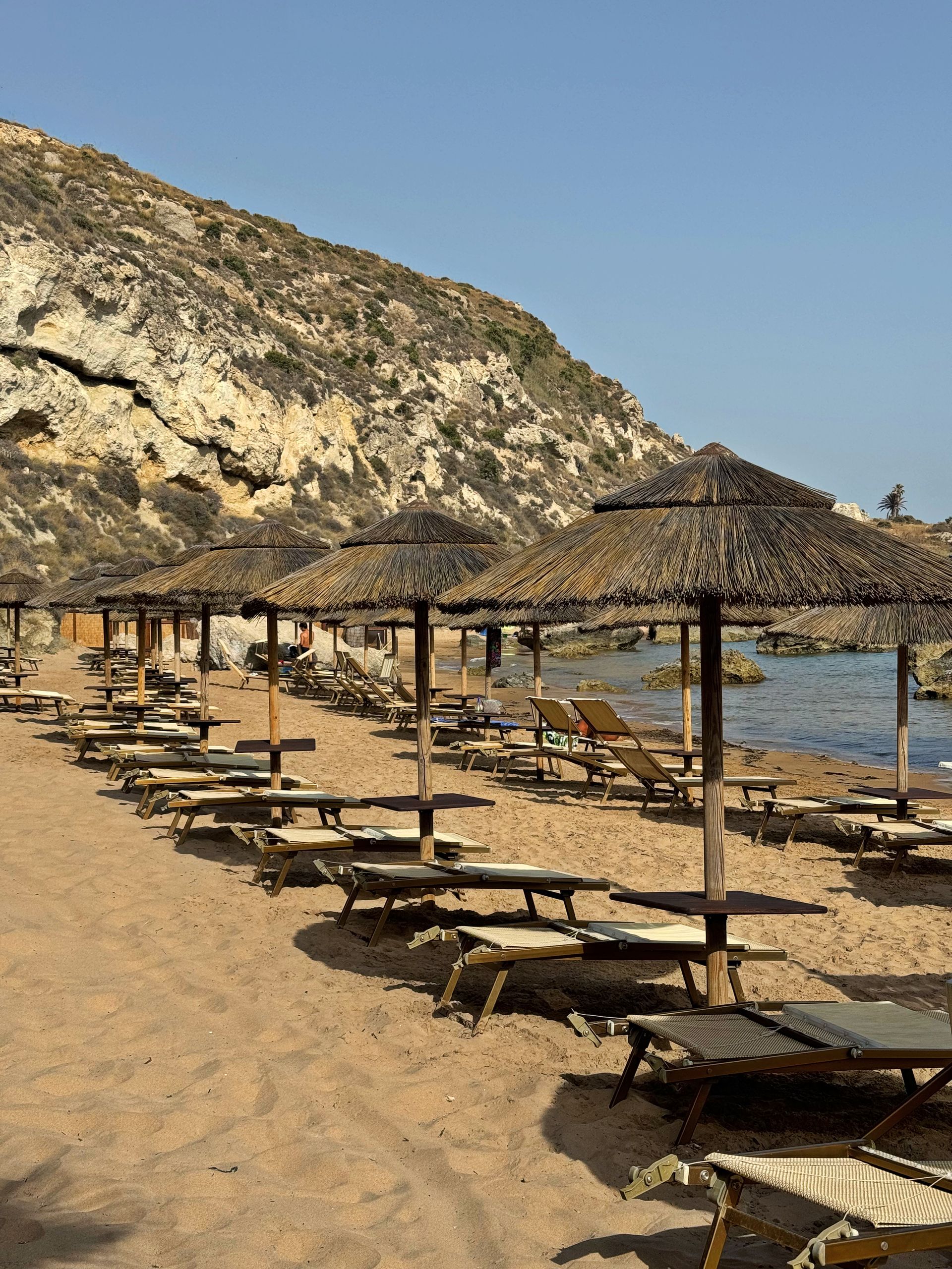 Una spiaggia con tante sedie e ombrelloni
