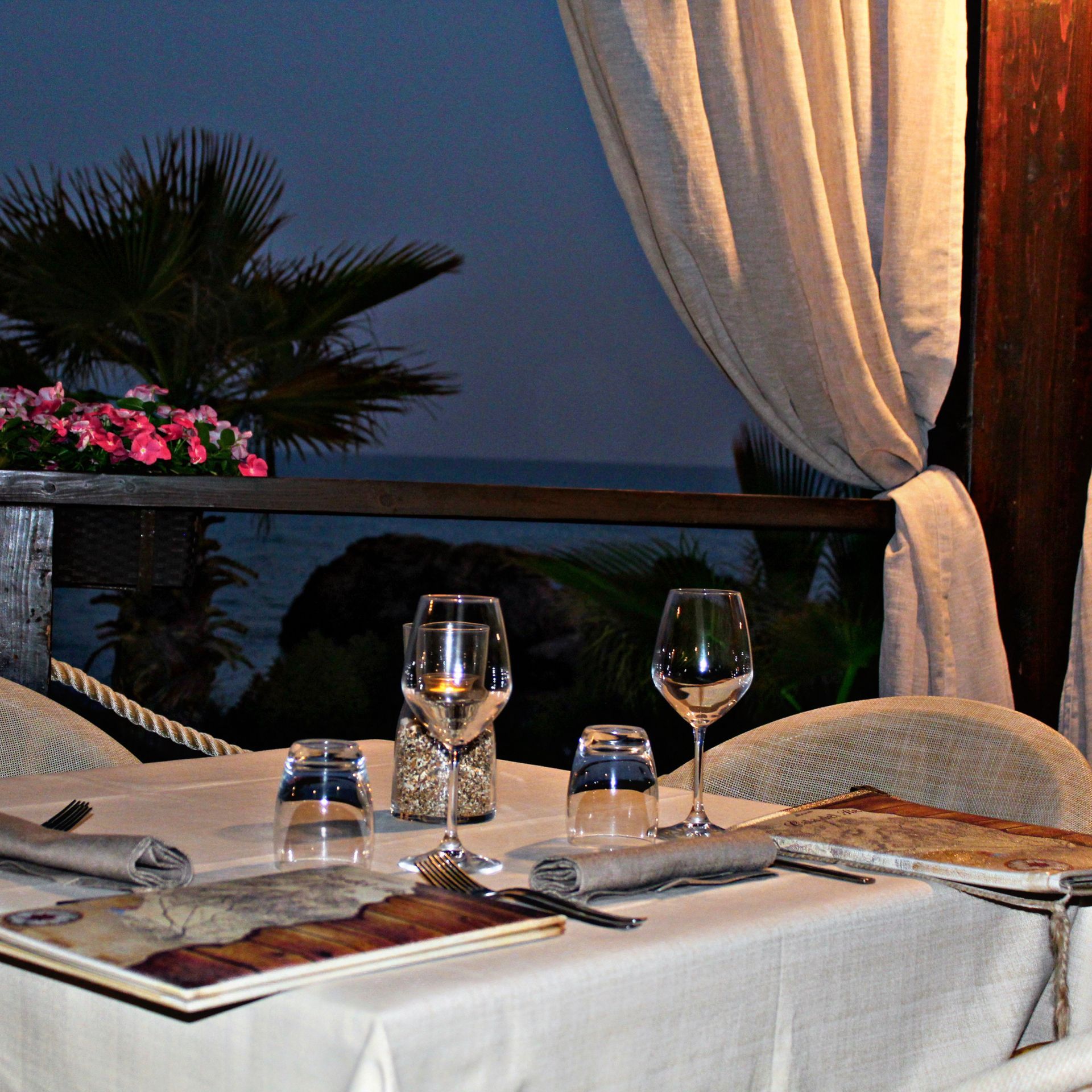 Un tavolo con bicchieri da vino e un menu sopra