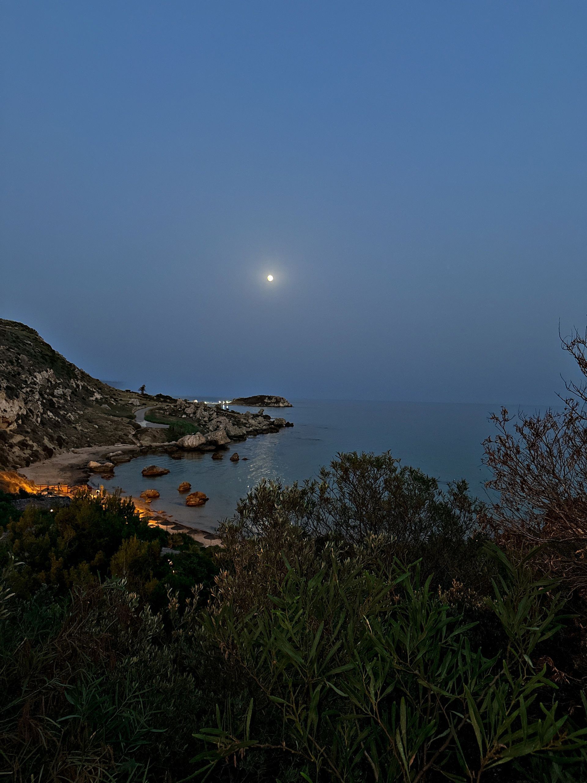 Una luna piena splende su uno specchio d'acqua