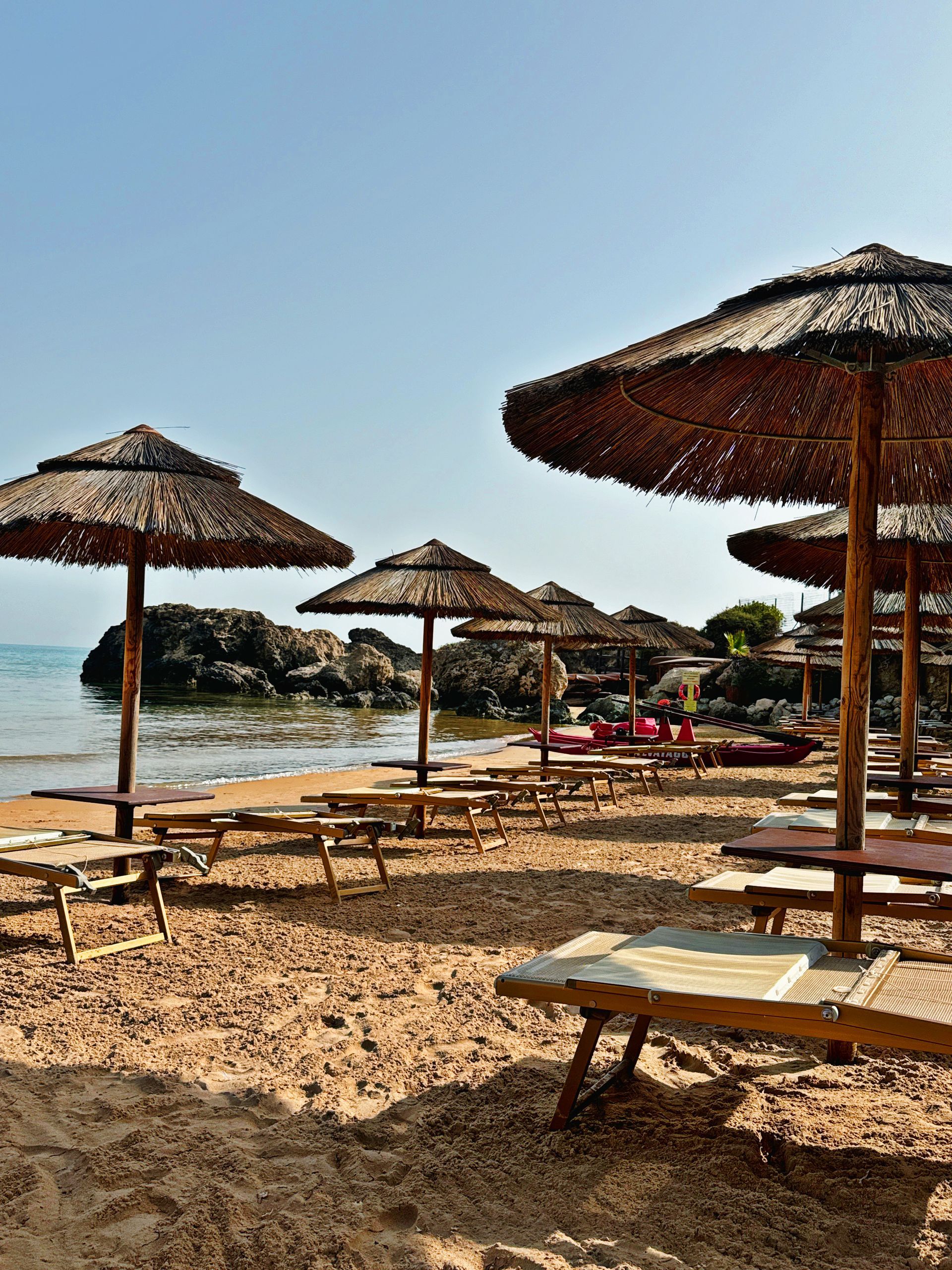 Una spiaggia con molti ombrelloni e sedie