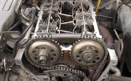 A close up of a car engine with chains on it.  | Southwest Auto