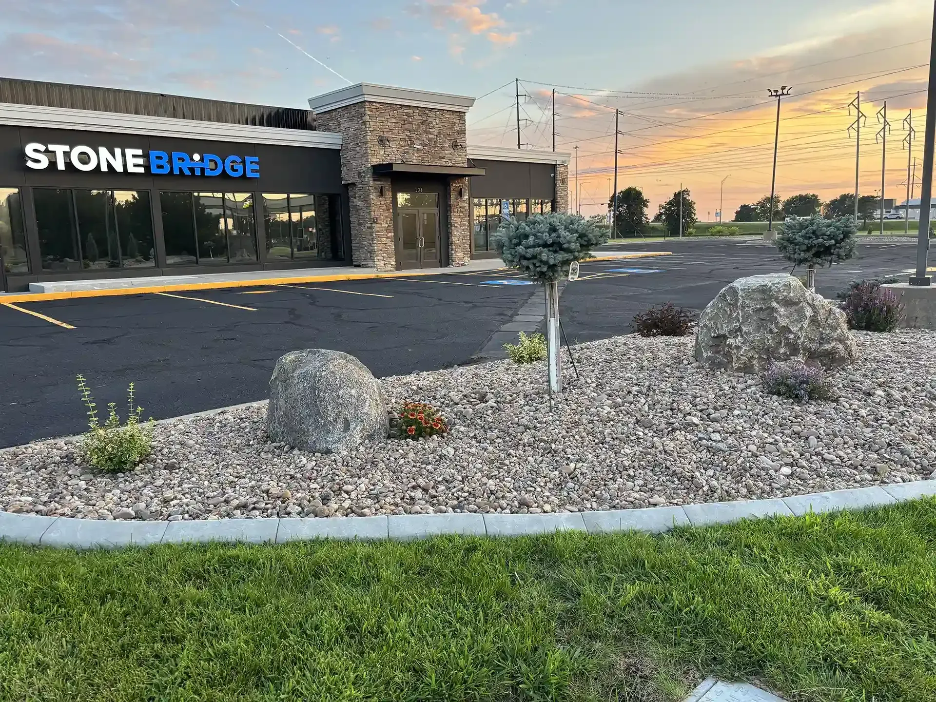 Stonebridge building exterior with landscaping featuring large rocks and gravel.