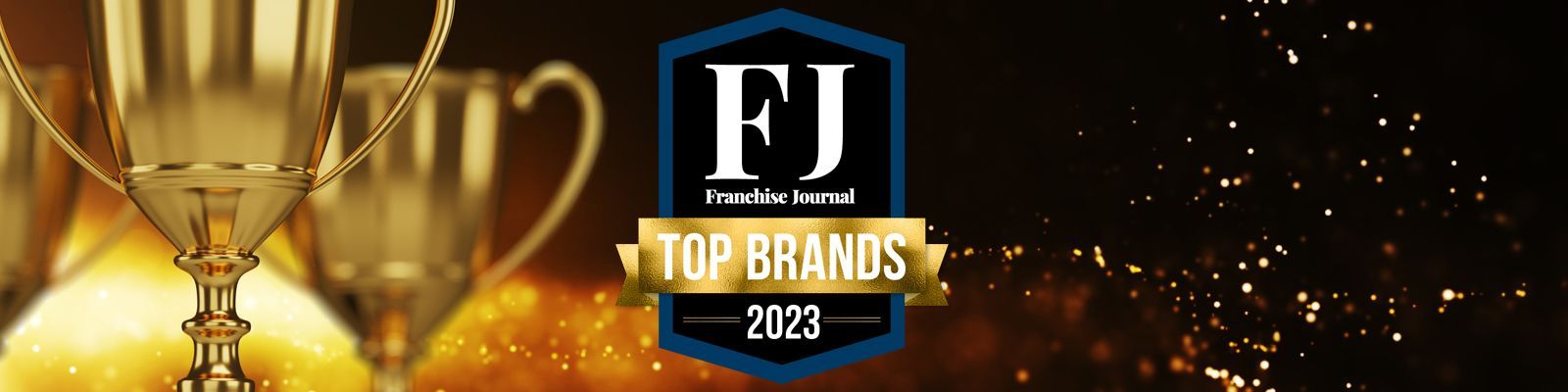 A trophy is sitting on top of a table next to a sign that says top brands.