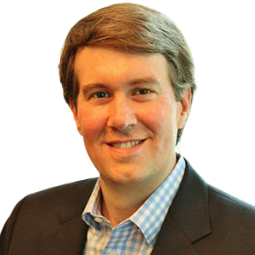 A man in a suit and plaid shirt smiles for the camera