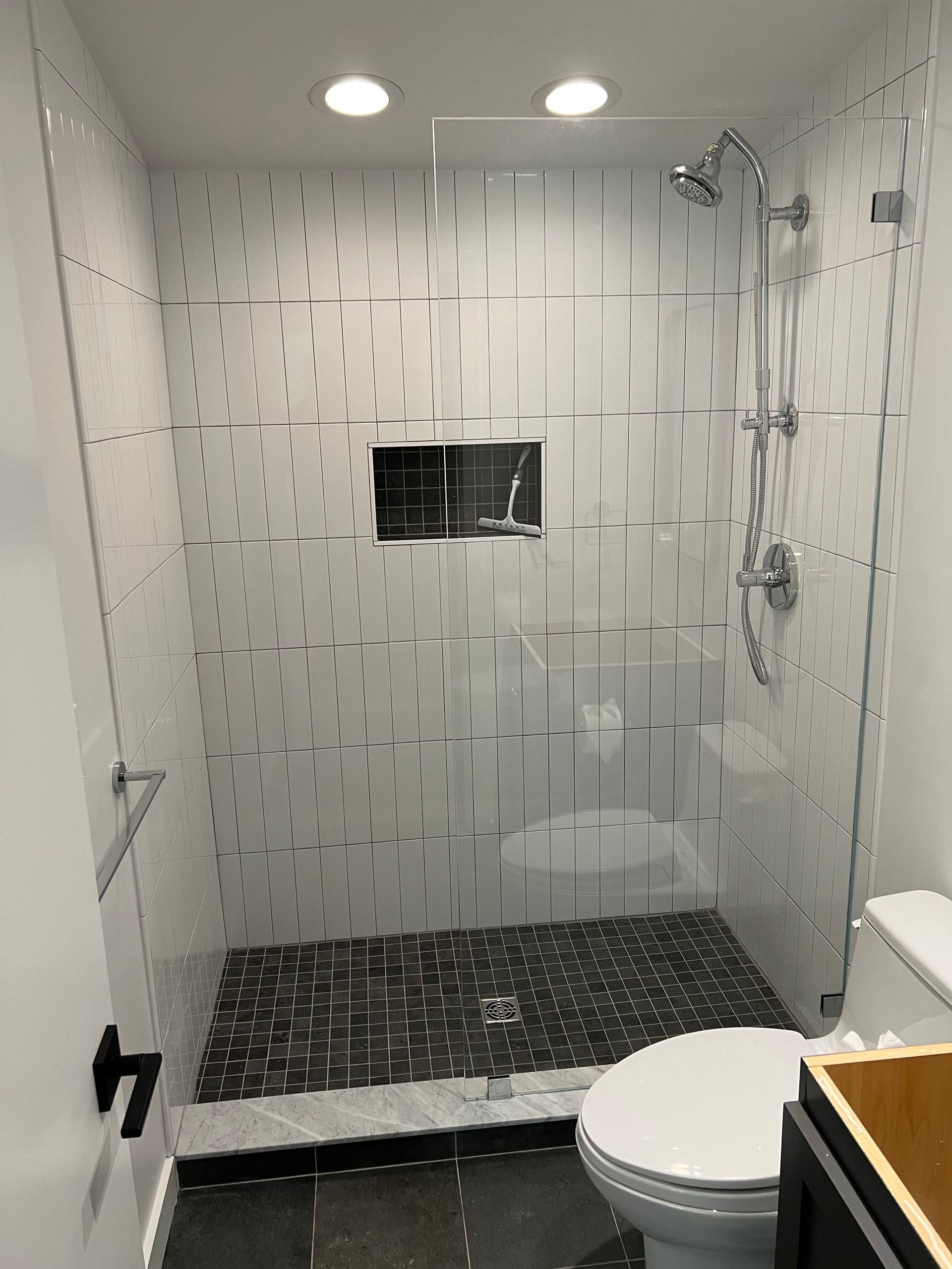 A bathroom with a toilet , shower , and sink.