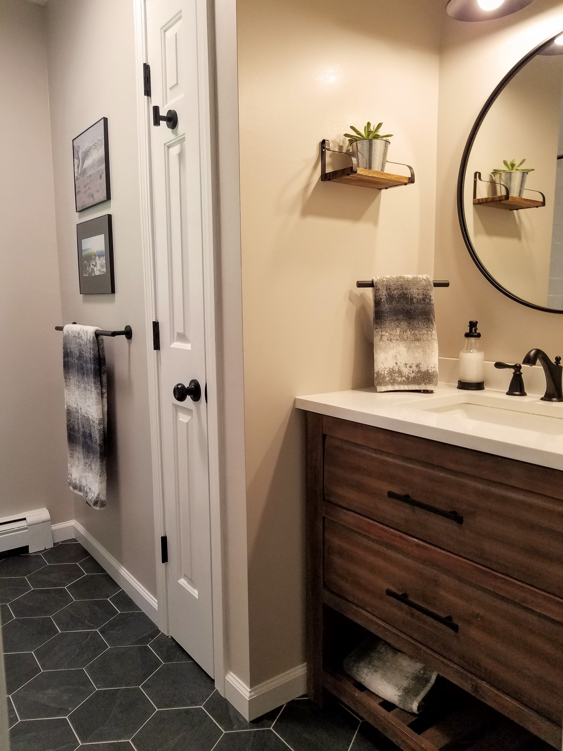 A bathroom with a sink and a round mirror