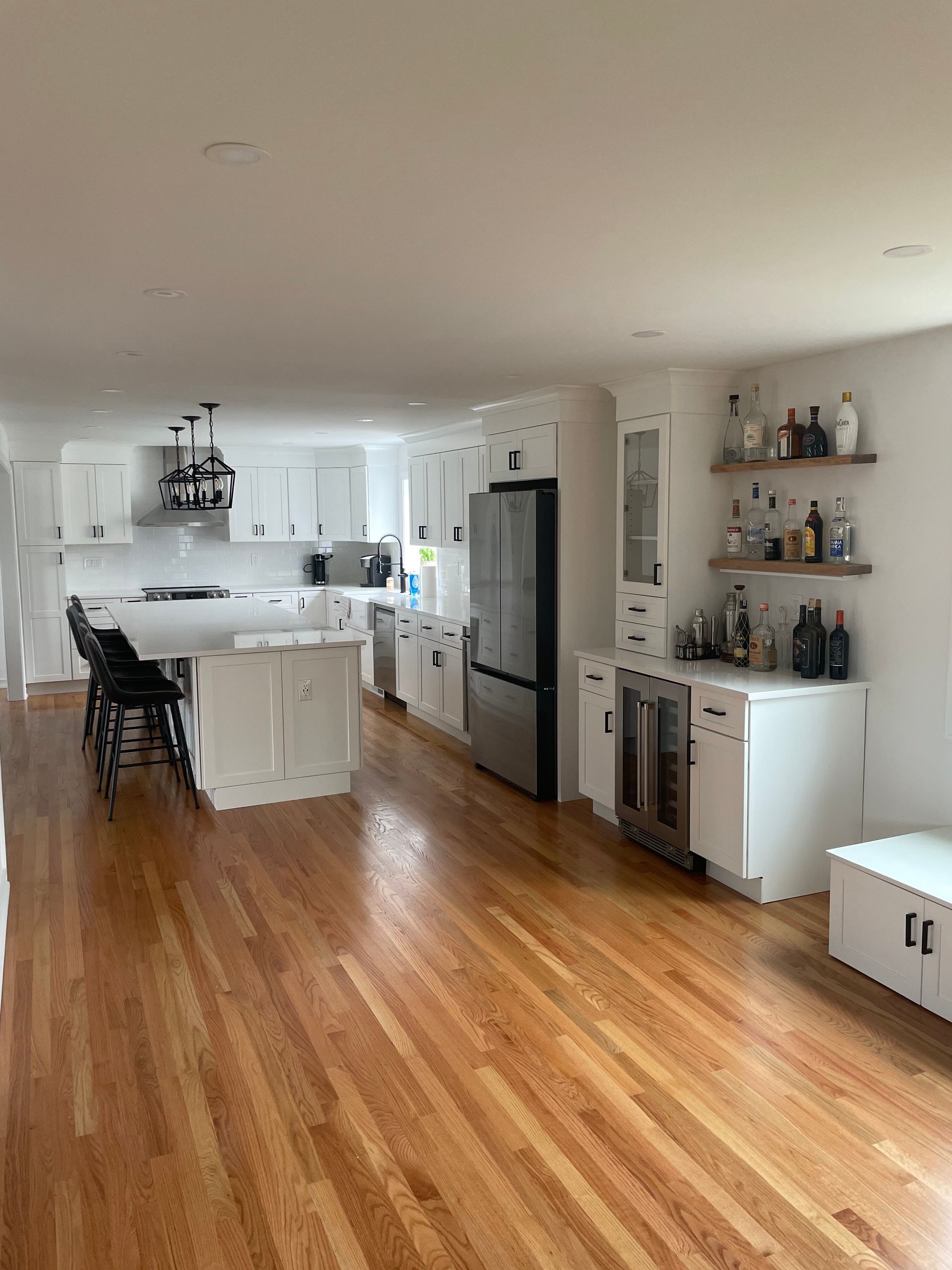 A large kitchen with hardwood floors and white cabinets.