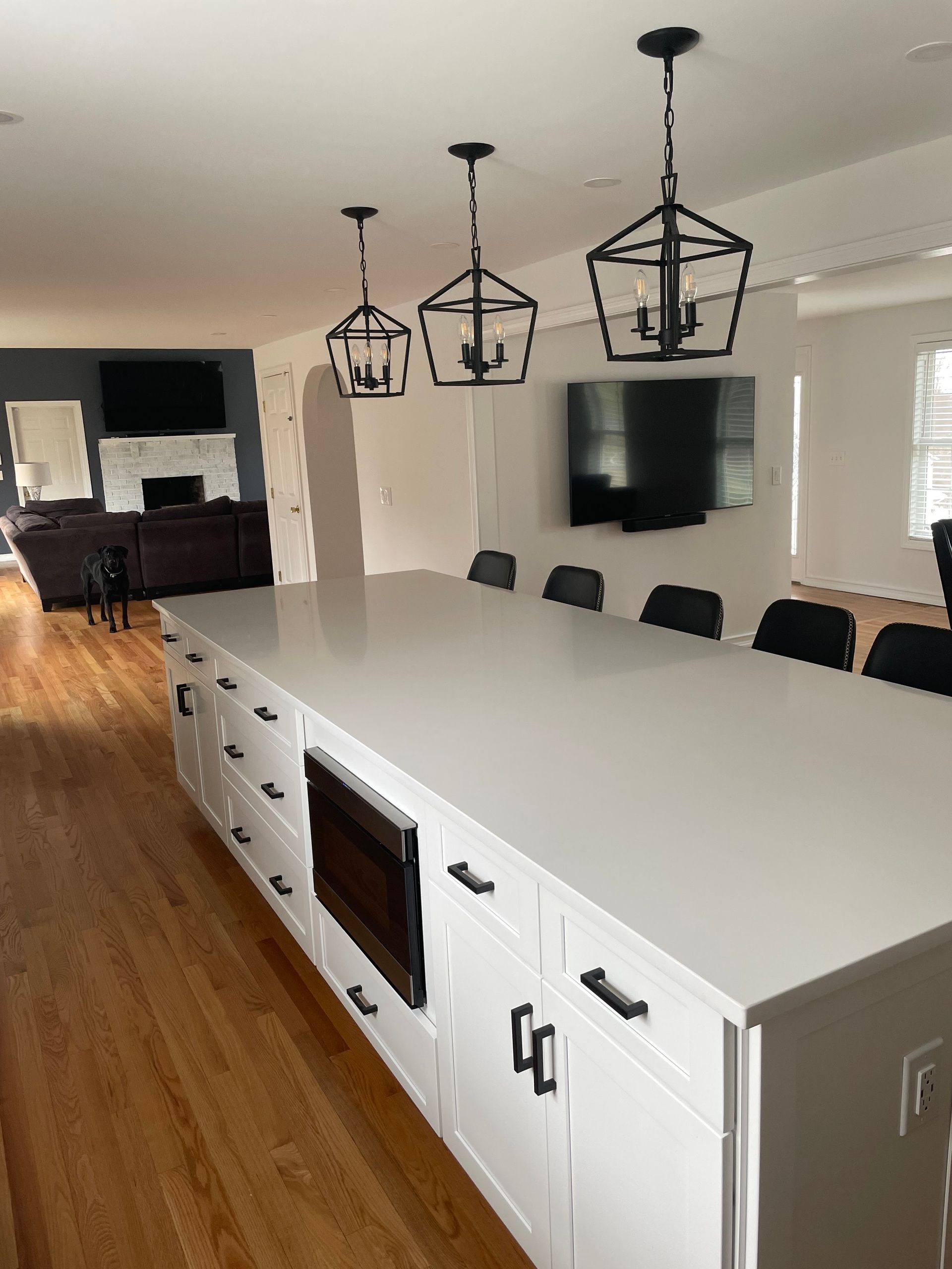A kitchen with a large island and white cabinets