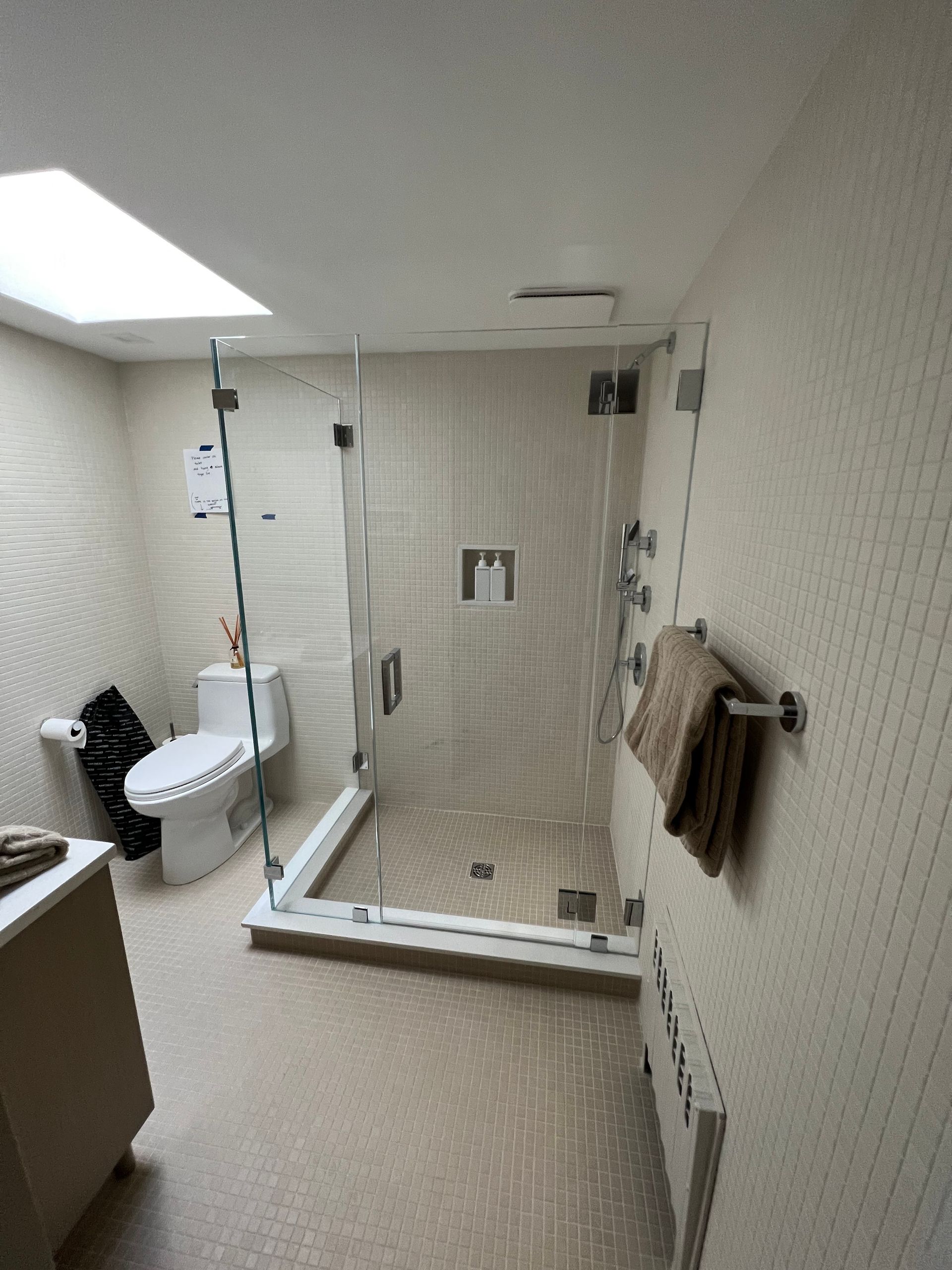A bathroom with a toilet and a walk in shower