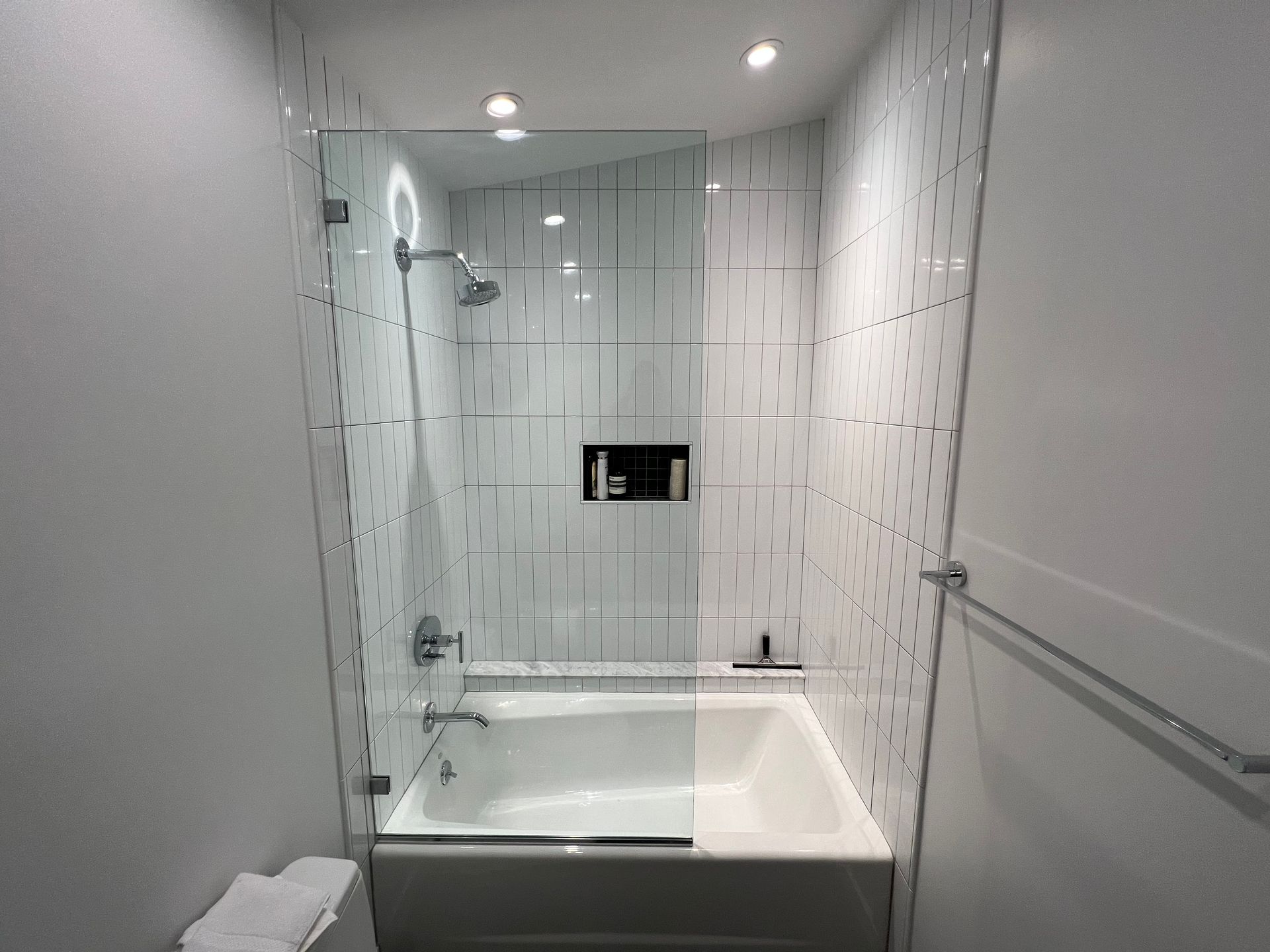 A bathroom with a bathtub and a shower with a glass door.