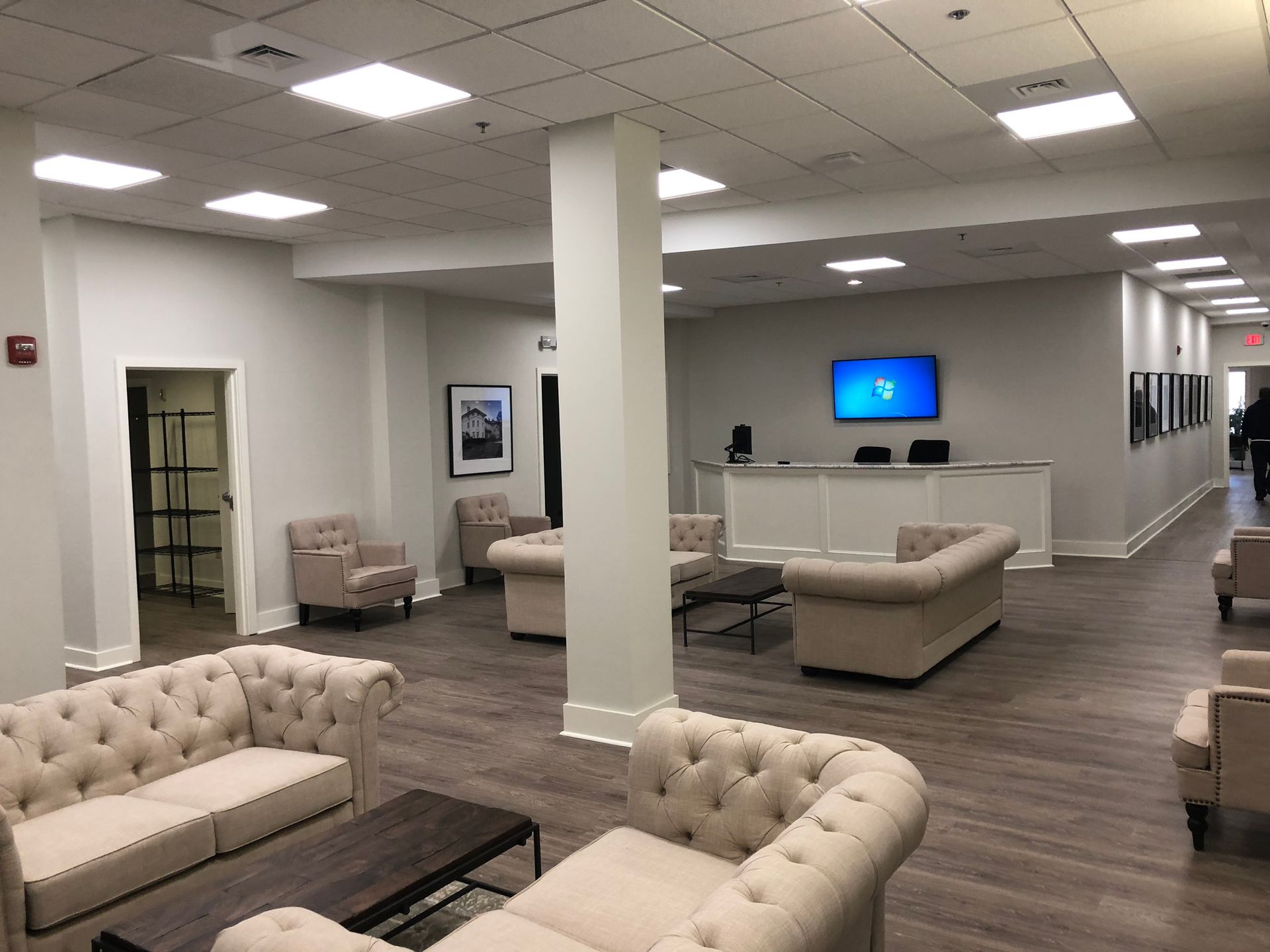 A living room with a lot of furniture and a television on the wall.