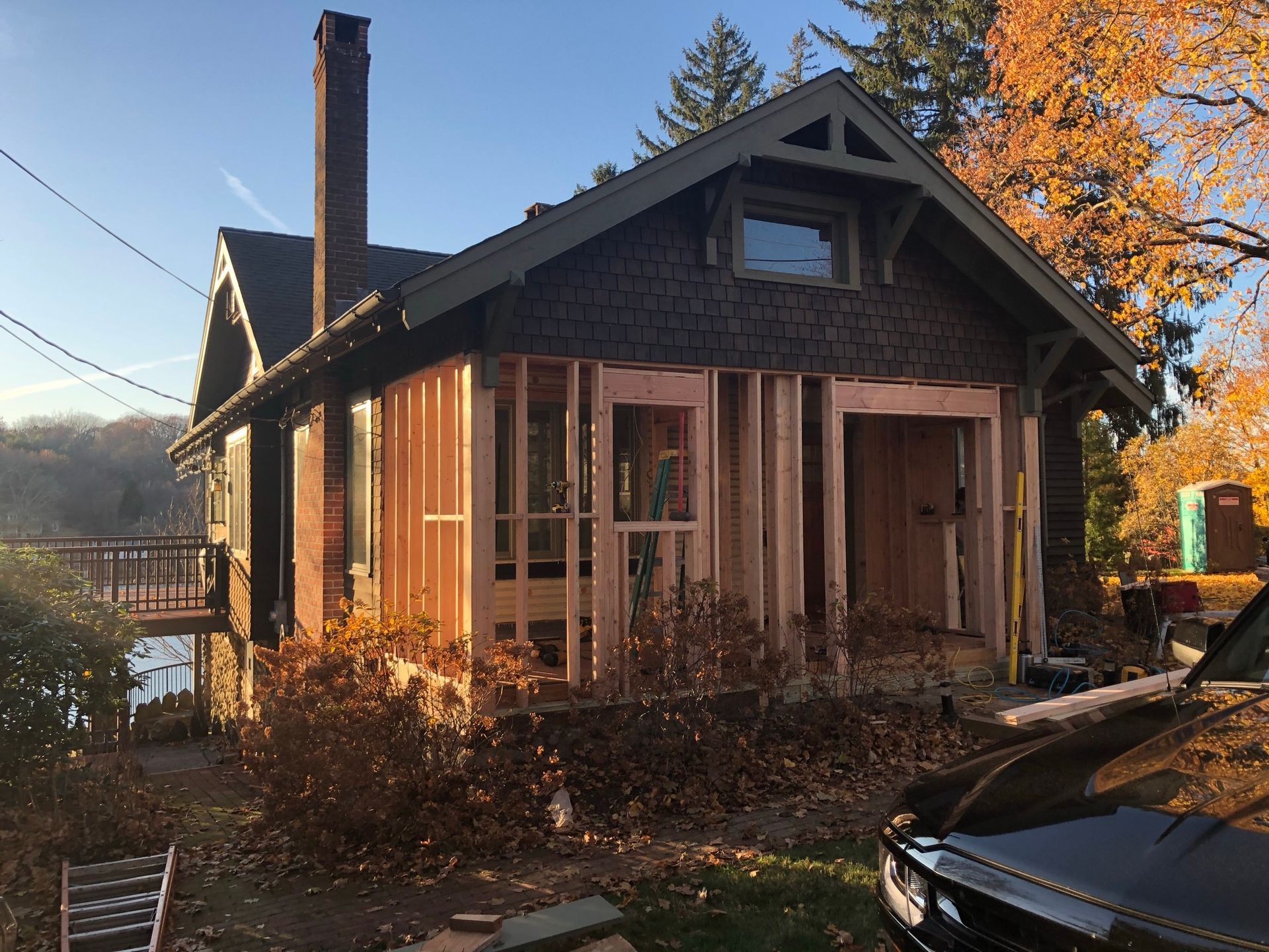 A house is being remodeled and a truck is parked in front of it.
