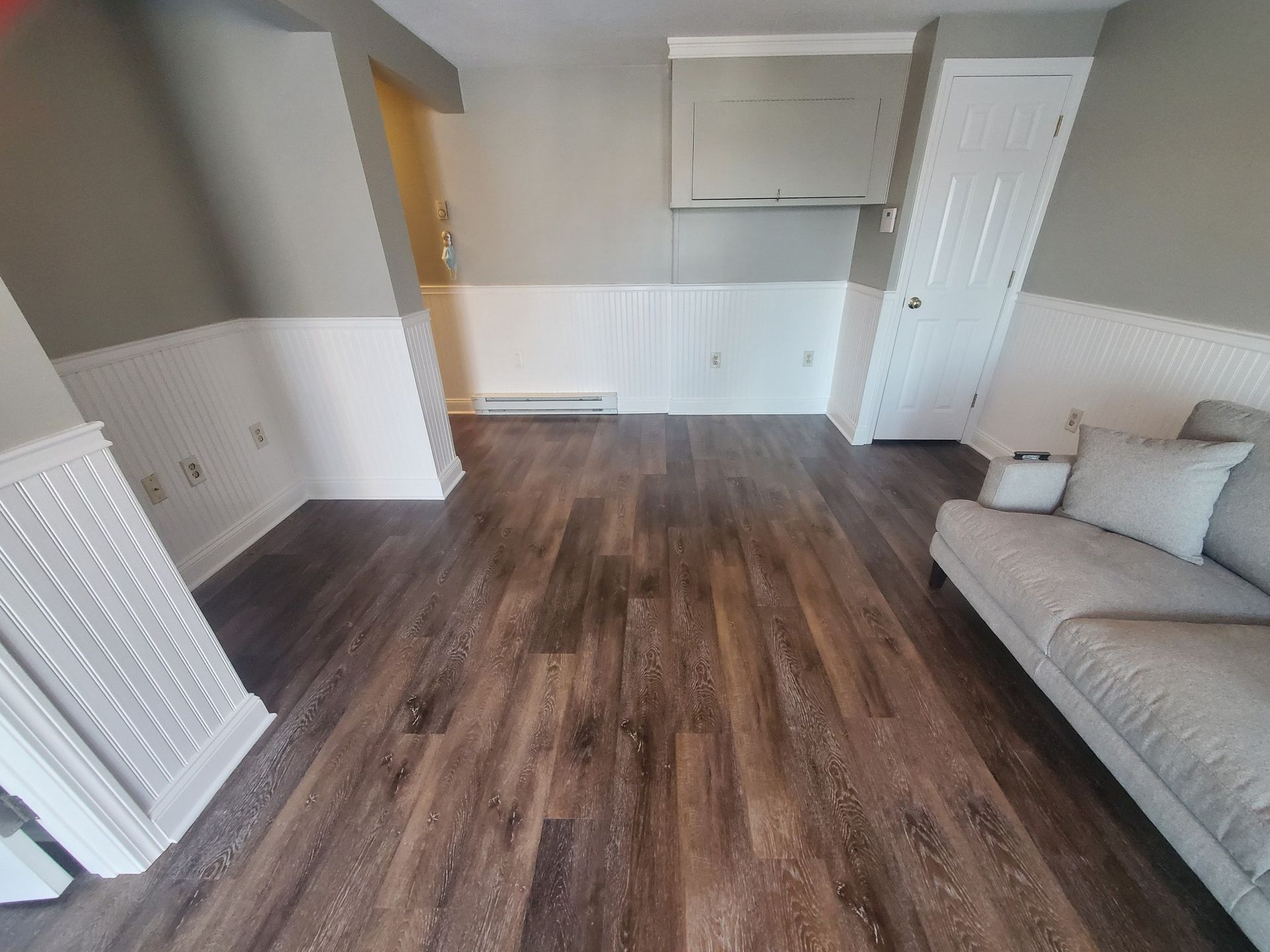 A living room with hardwood floors and a couch.