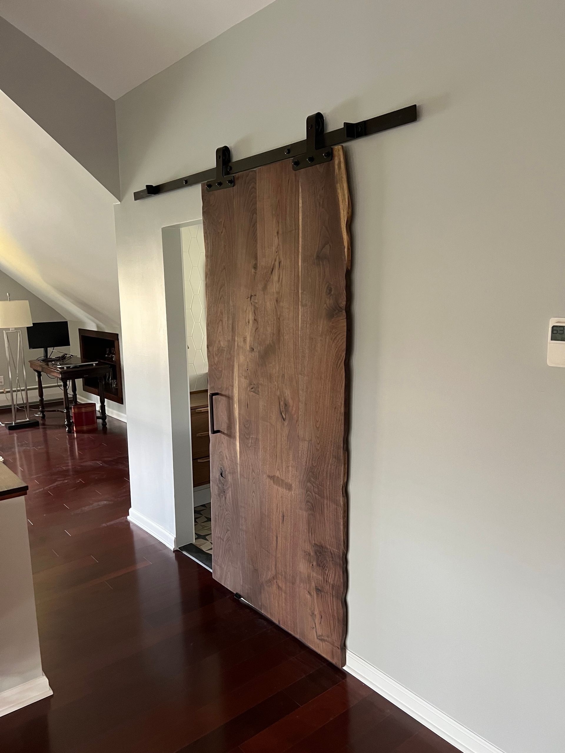 A wooden sliding barn door is hanging on a wall in a living room.