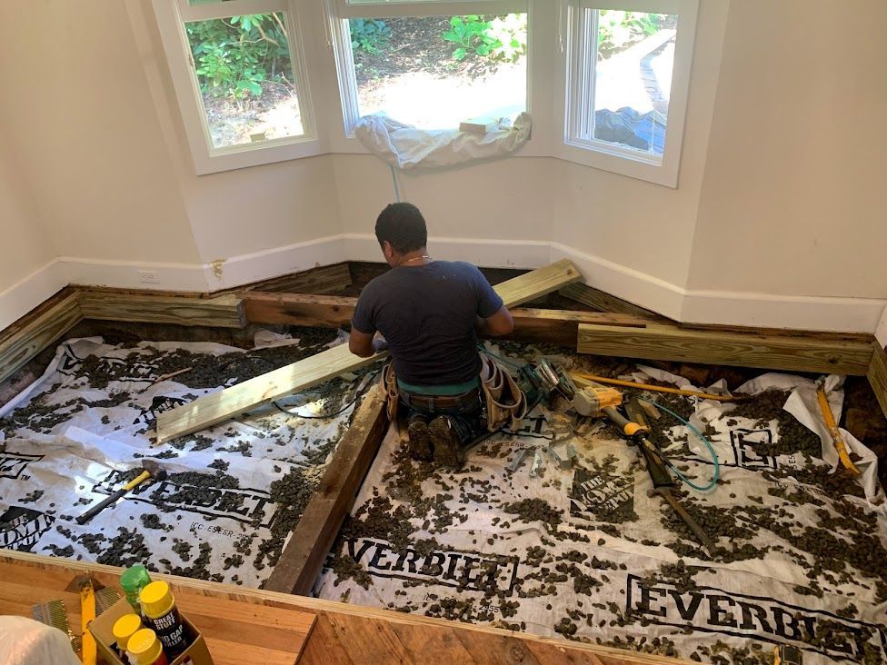 A man is kneeling down on the floor in a room.