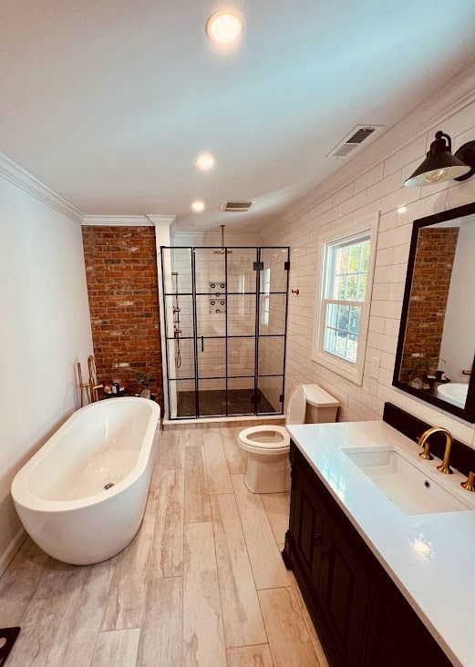 A bathroom with a tub , sink , toilet and shower.