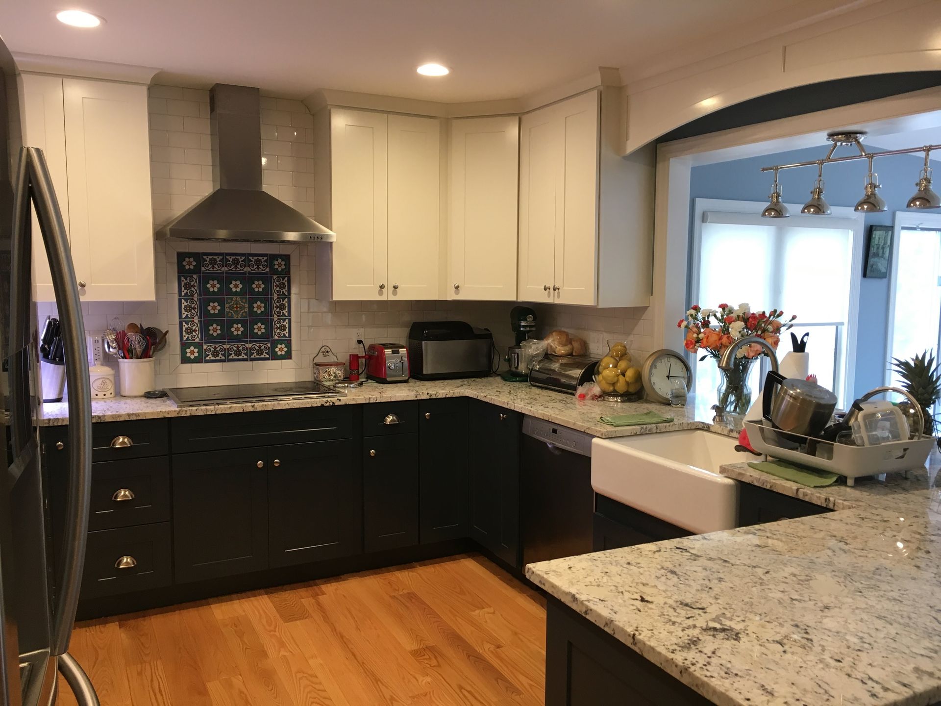 A kitchen with black cabinets and white counter tops and a sink.