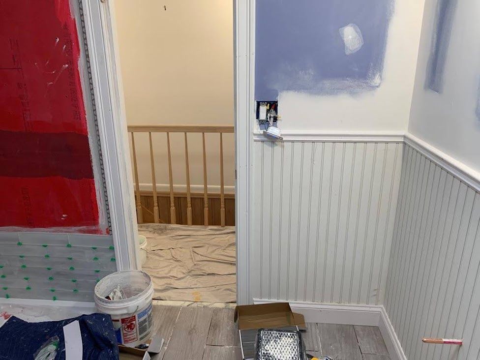 A room that is being painted with a staircase in the background.