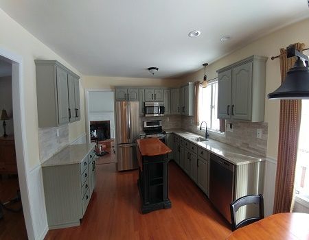 A kitchen with stainless steel appliances and gray cabinets