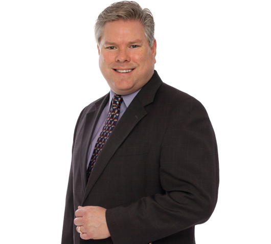 A man in a suit and tie is smiling for the camera