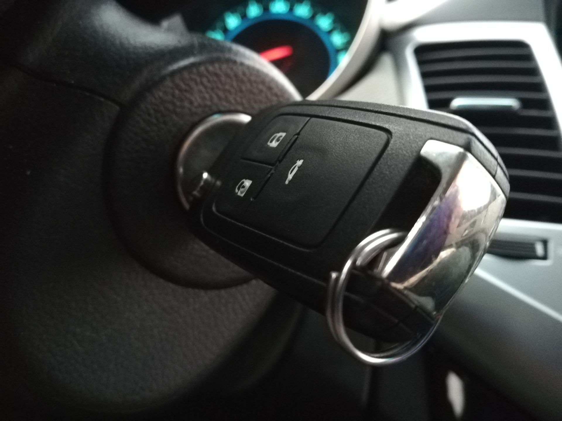 A car key is sitting on the steering wheel of a car