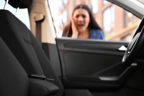 A woman is sitting in the driver 's seat of a car.