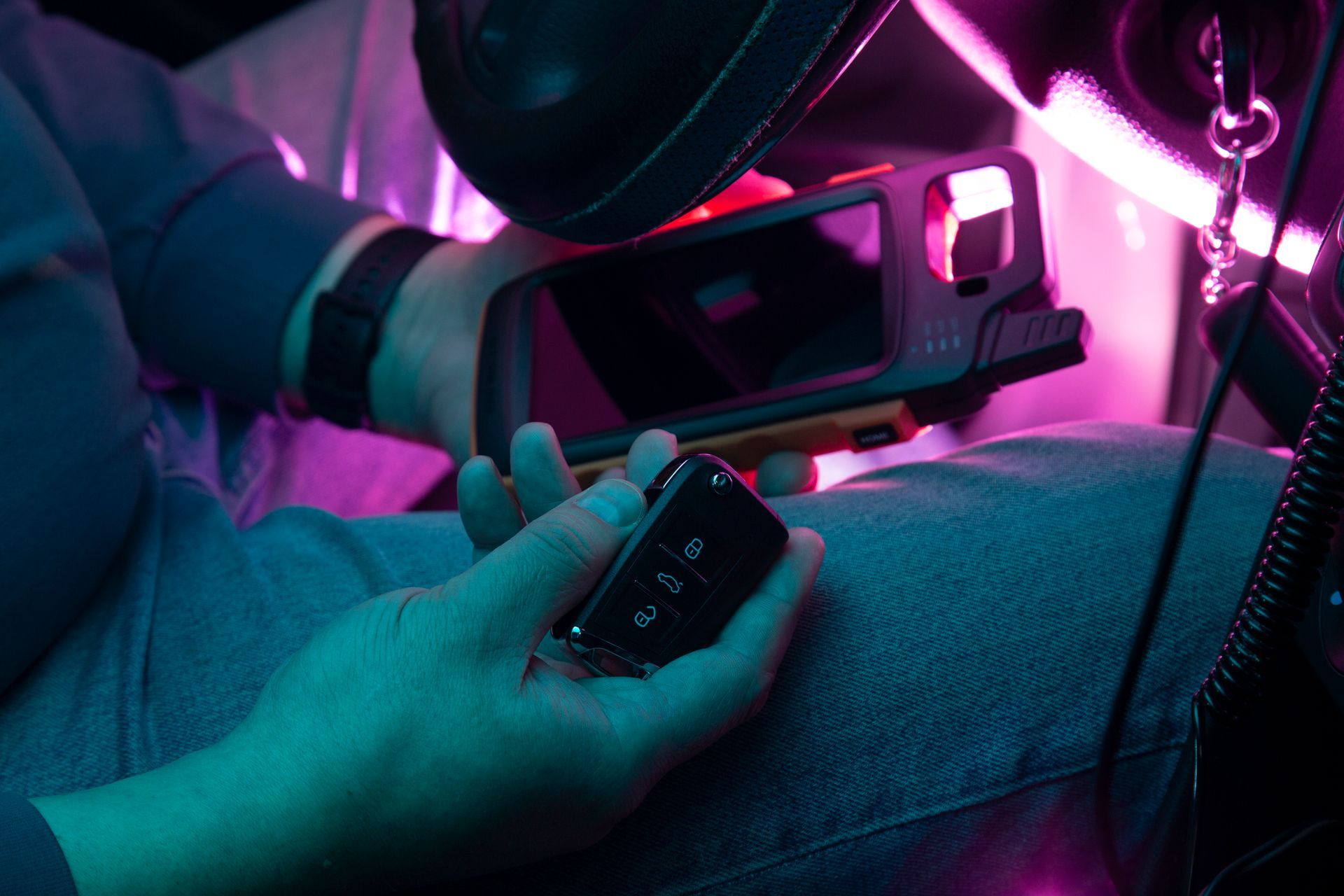 A person is sitting in a car holding a device. A person is sitting in a car holding a device.