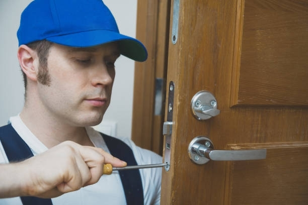 A man is fixing a door with a screwdriver.
