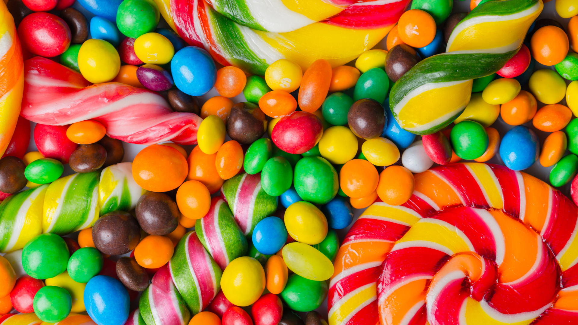 A pile of colorful candies and lollipops on a table.