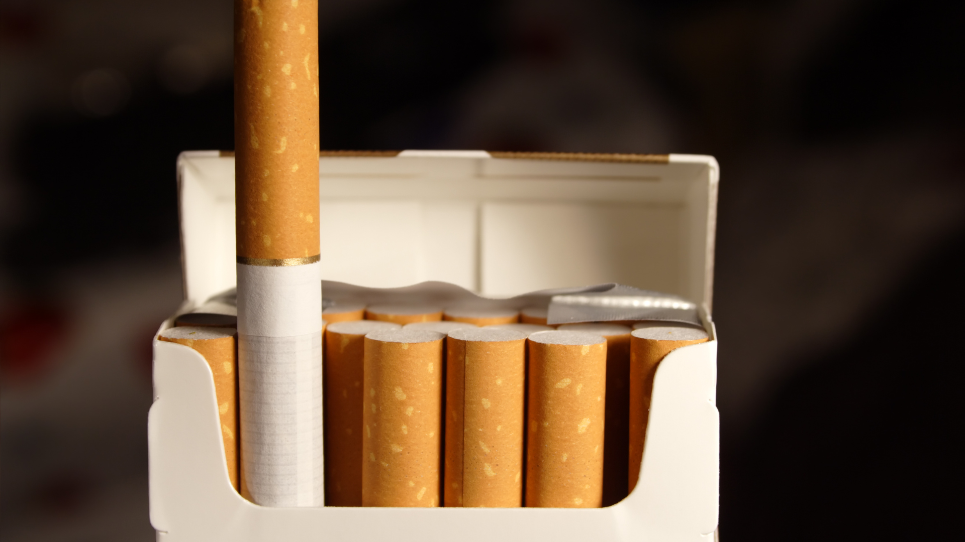 A pack of cigarettes with one sticking out of it