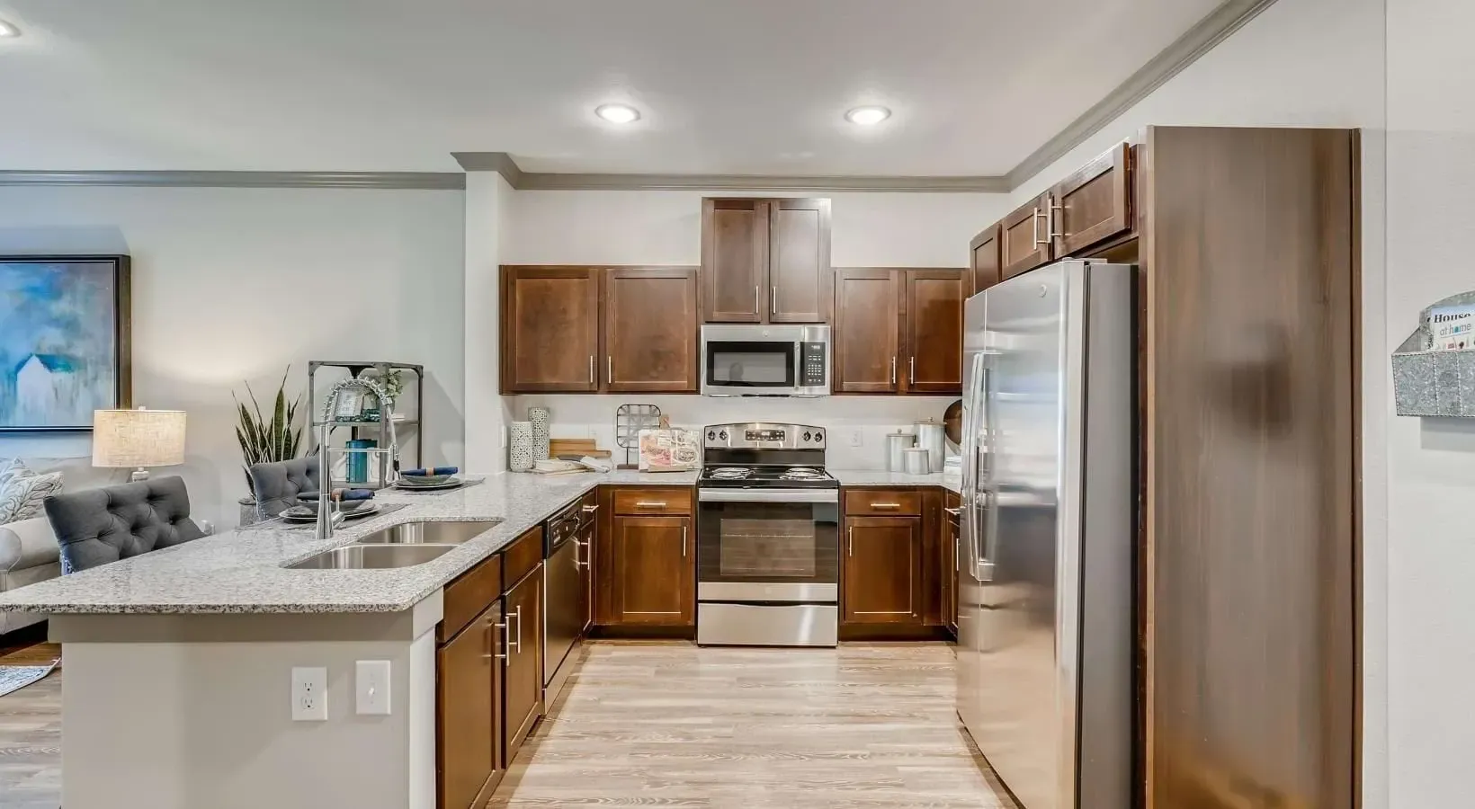Modern kitchen with dark wood cabinets, granite countertops, and stainless steel appliances.