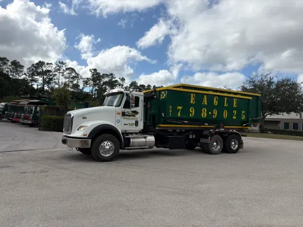 A garbage truck from eagle is parked in a parking lot