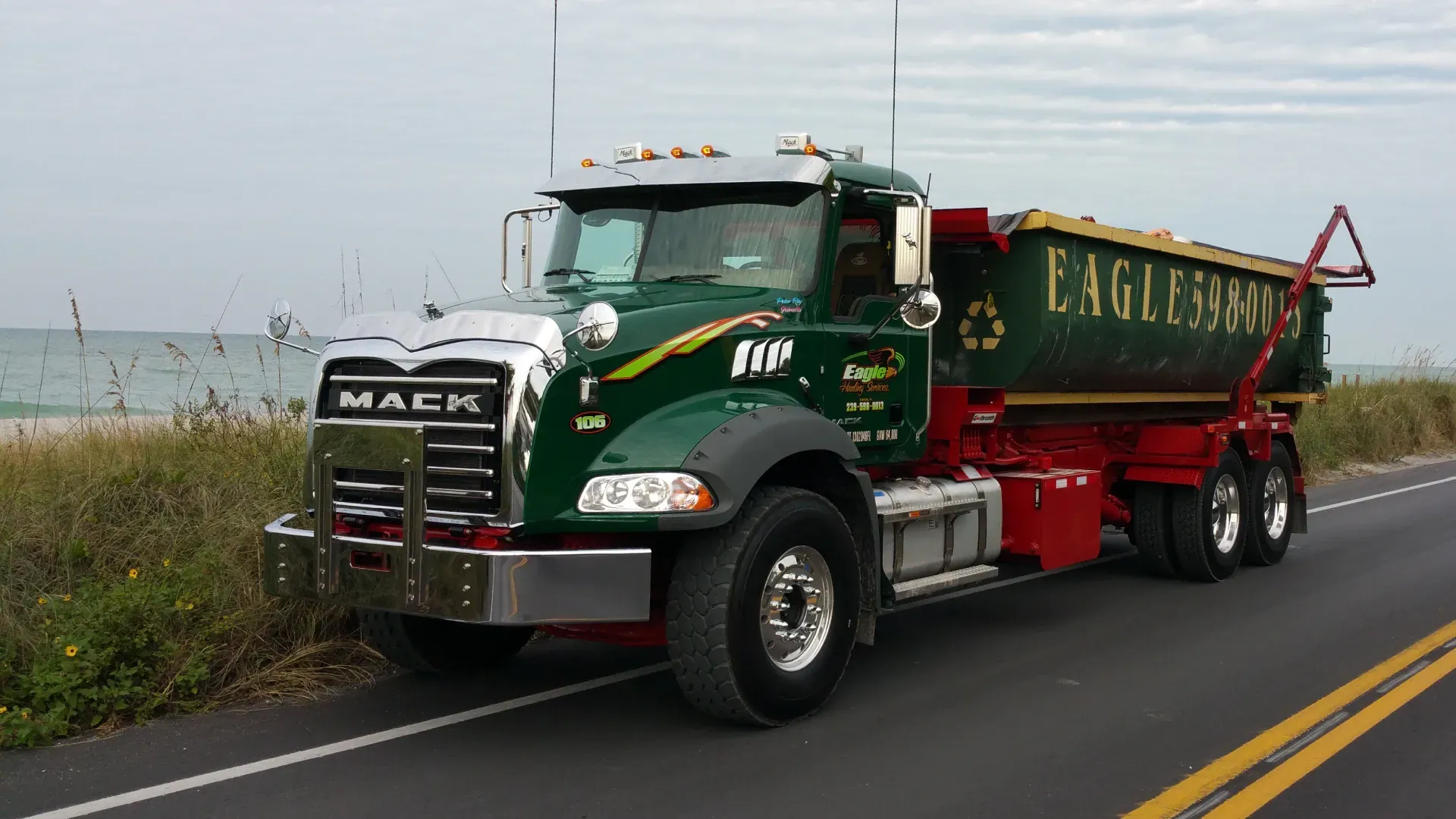 A mack dump truck is parked on the side of the road