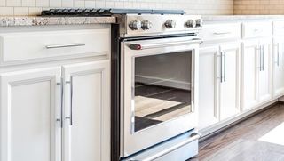 A kitchen with white cabinets and a stove and oven.