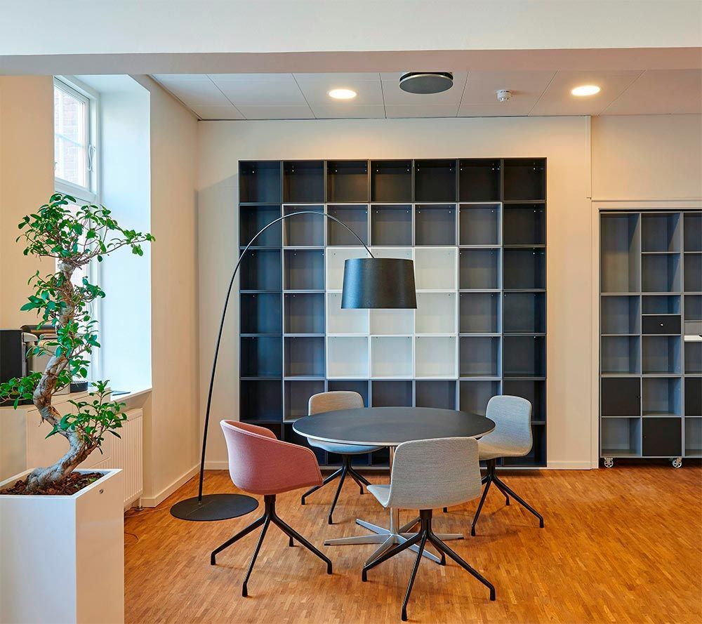 A room with a table and chairs and a lamp