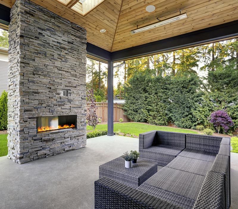 A patio with a fireplace and a couch.