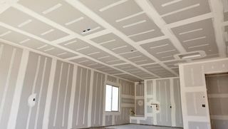 An empty room with drywall on the walls and ceiling.