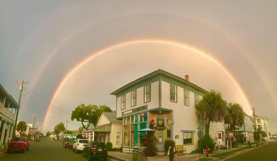 A double rainbow is visible over a small town.