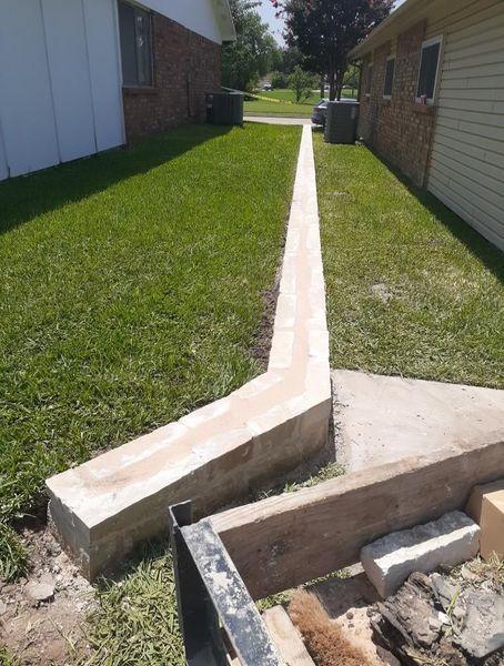 Brick house exterior with entryway, planter boxes, and garage. Construction materials are on the lawn.