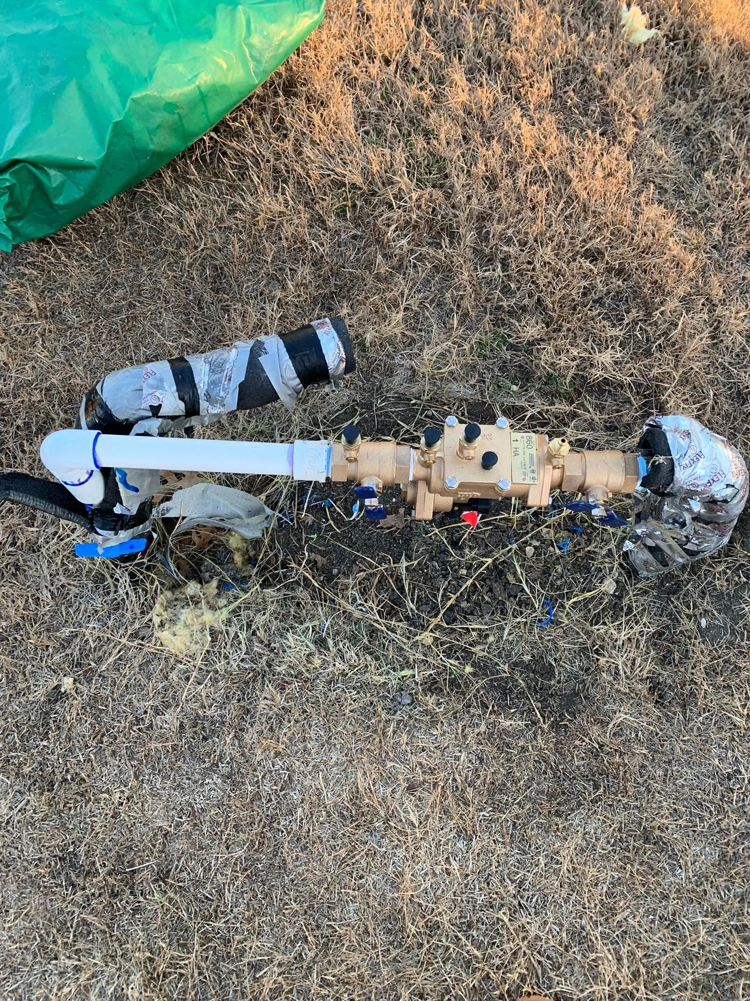 Irrigation system with valves and pipes on dry ground, wrapped in insulation and connected