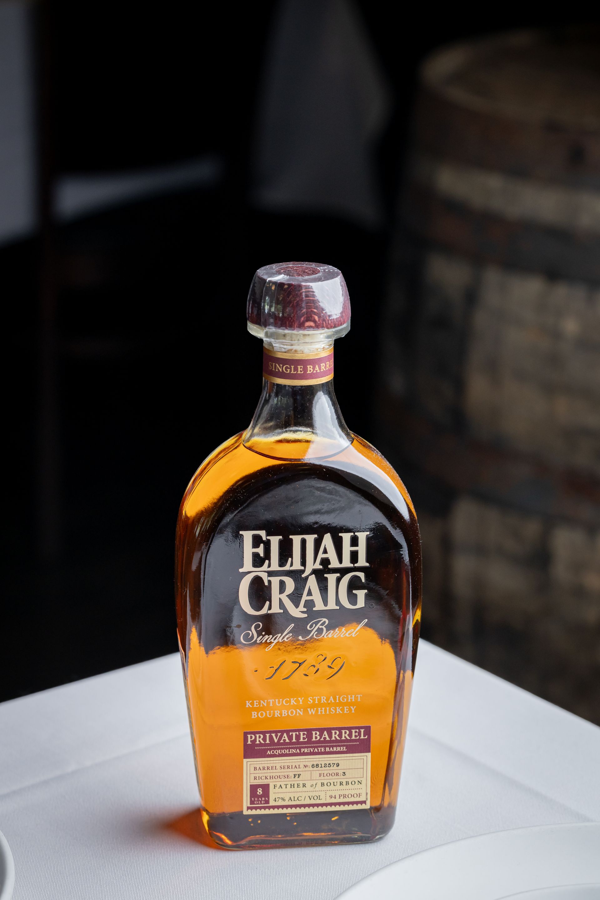 A bottle of elijah craig whiskey is sitting on a table.