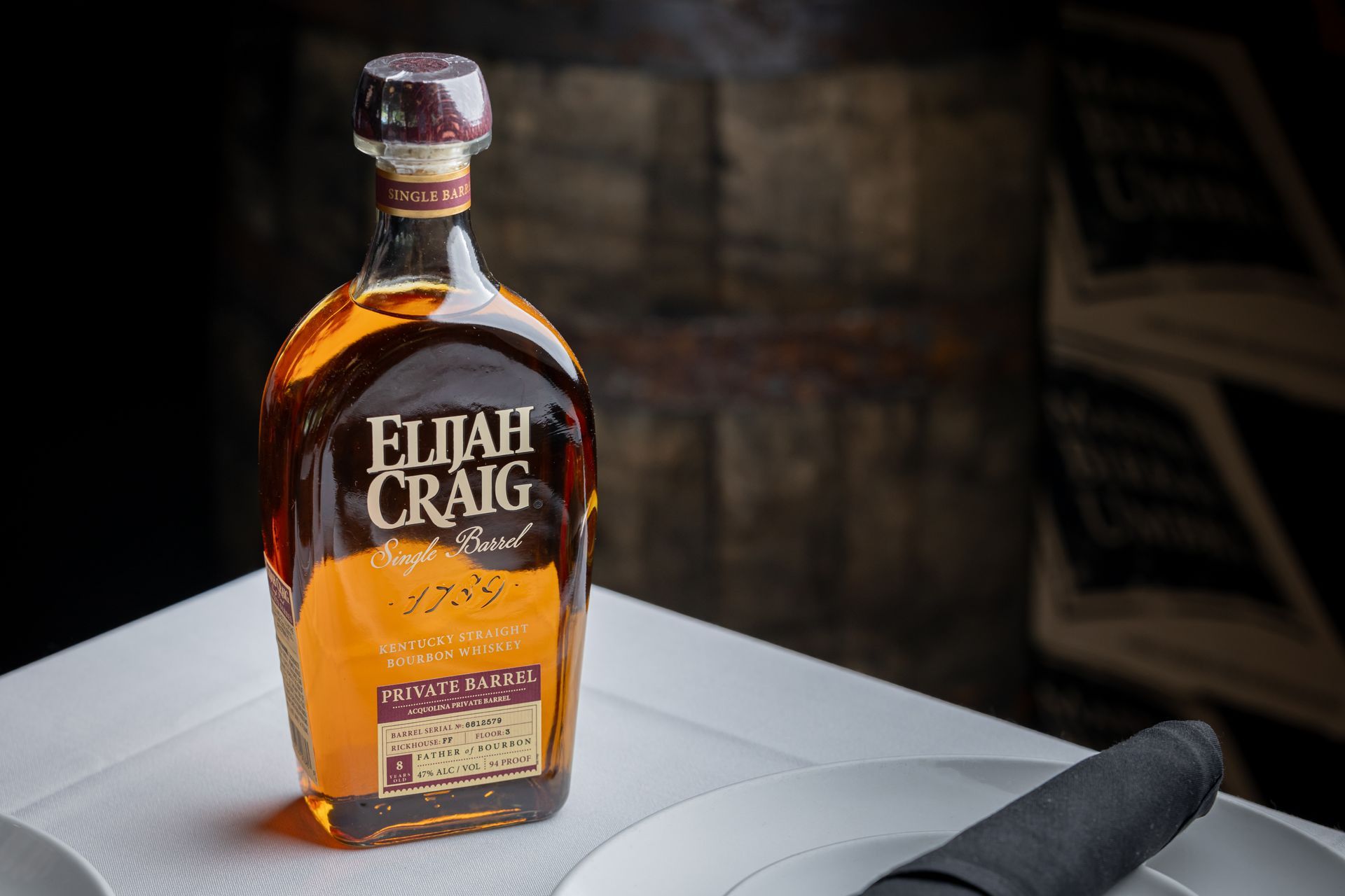 A bottle of elijah craig whiskey is sitting on a table.