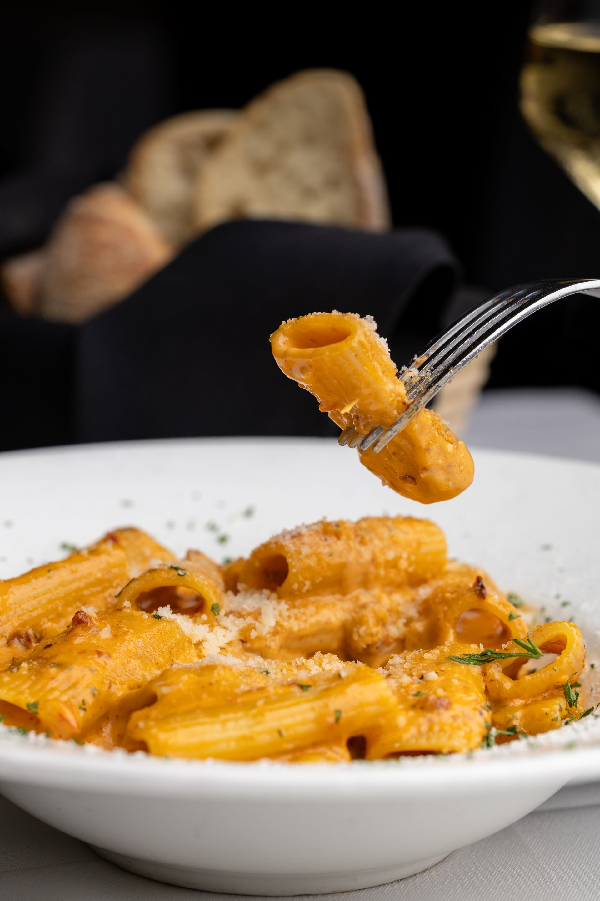 A close up of a person eating pasta with a fork.