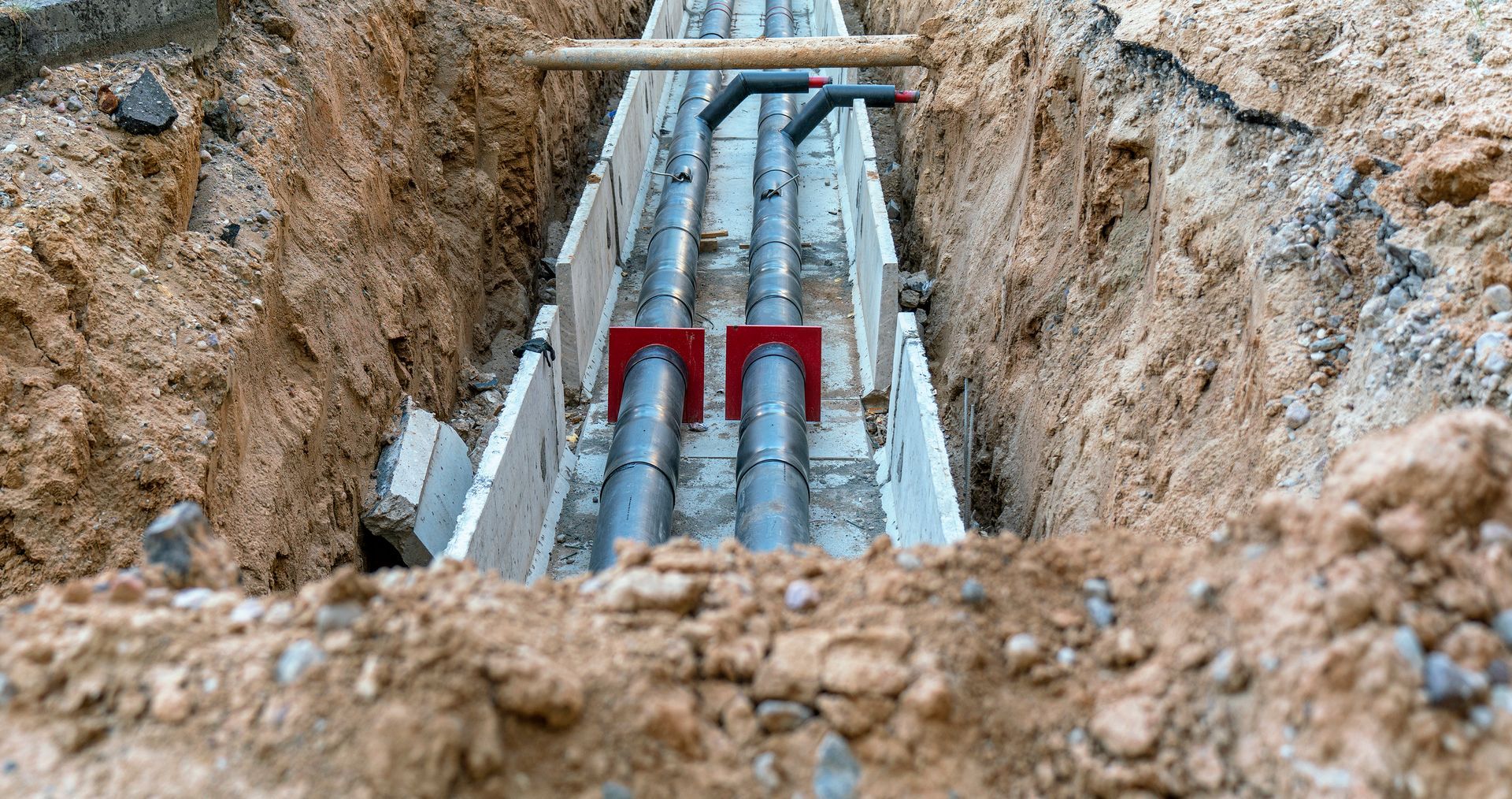 A pipe is being installed in a trench in the dirt.