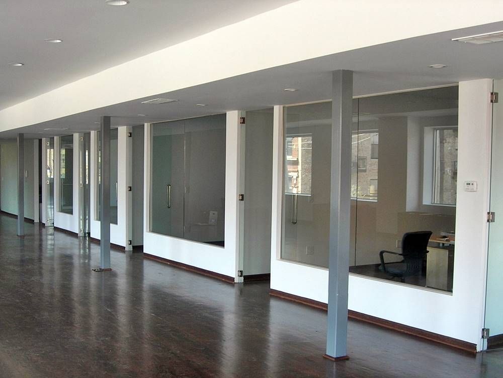 A long hallway with white walls and glass doors