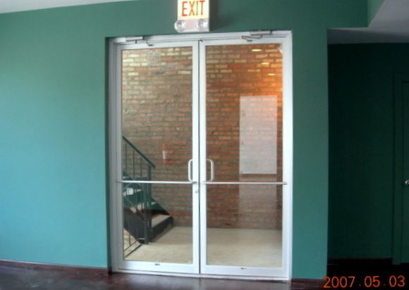 An exit sign is above a glass door